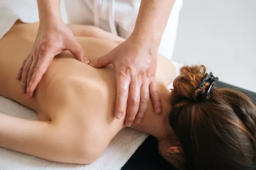 Therapist applying focused trigger point pressure to a client's upper back