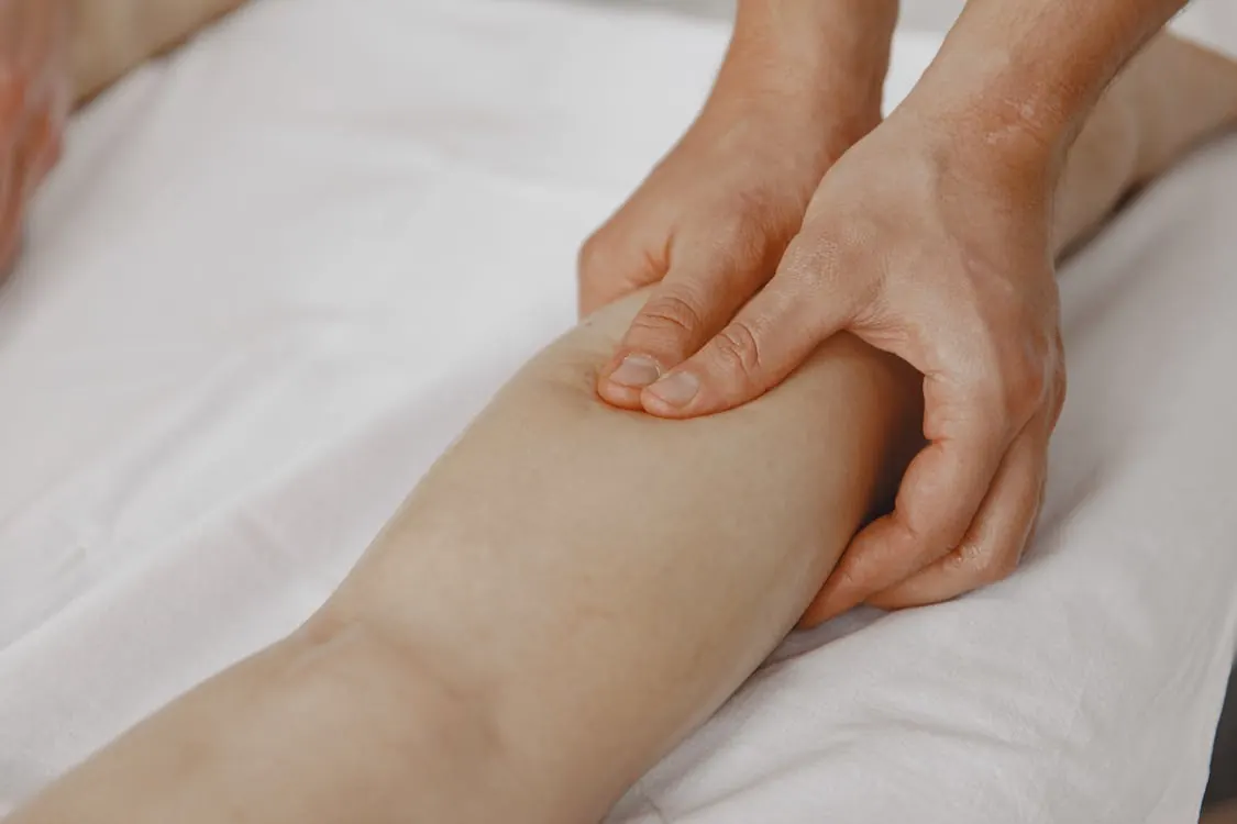 Therapist applying focused neuromuscular pressure to a client's calf